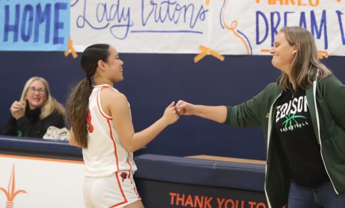 Lauryn Ham gets a fist bump from an Edison coach.